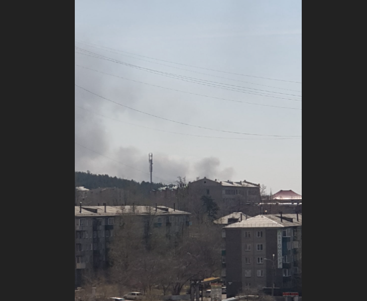 Дым за домами в Сосновом Бору в Чите